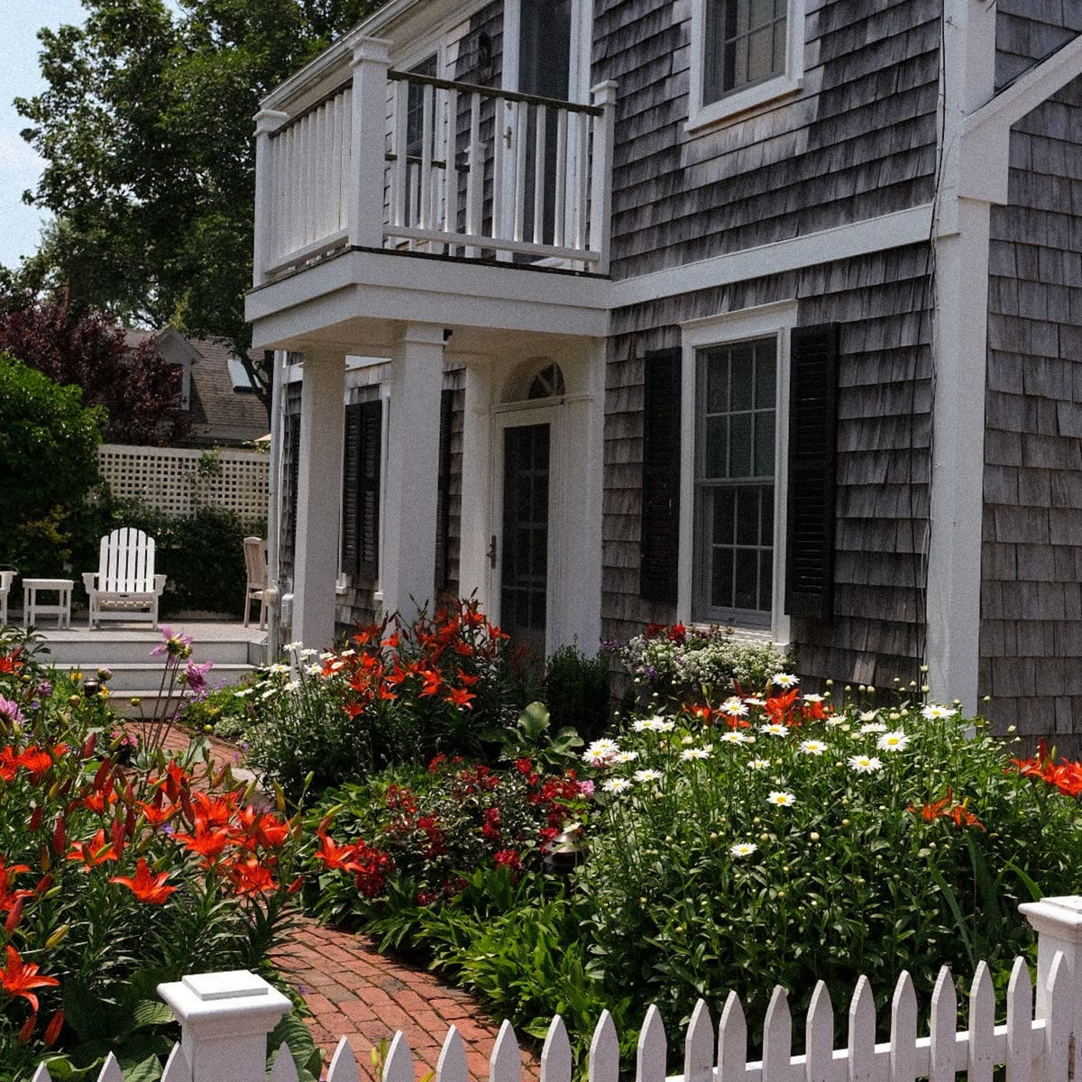 Shingled entry with columns and summer garden