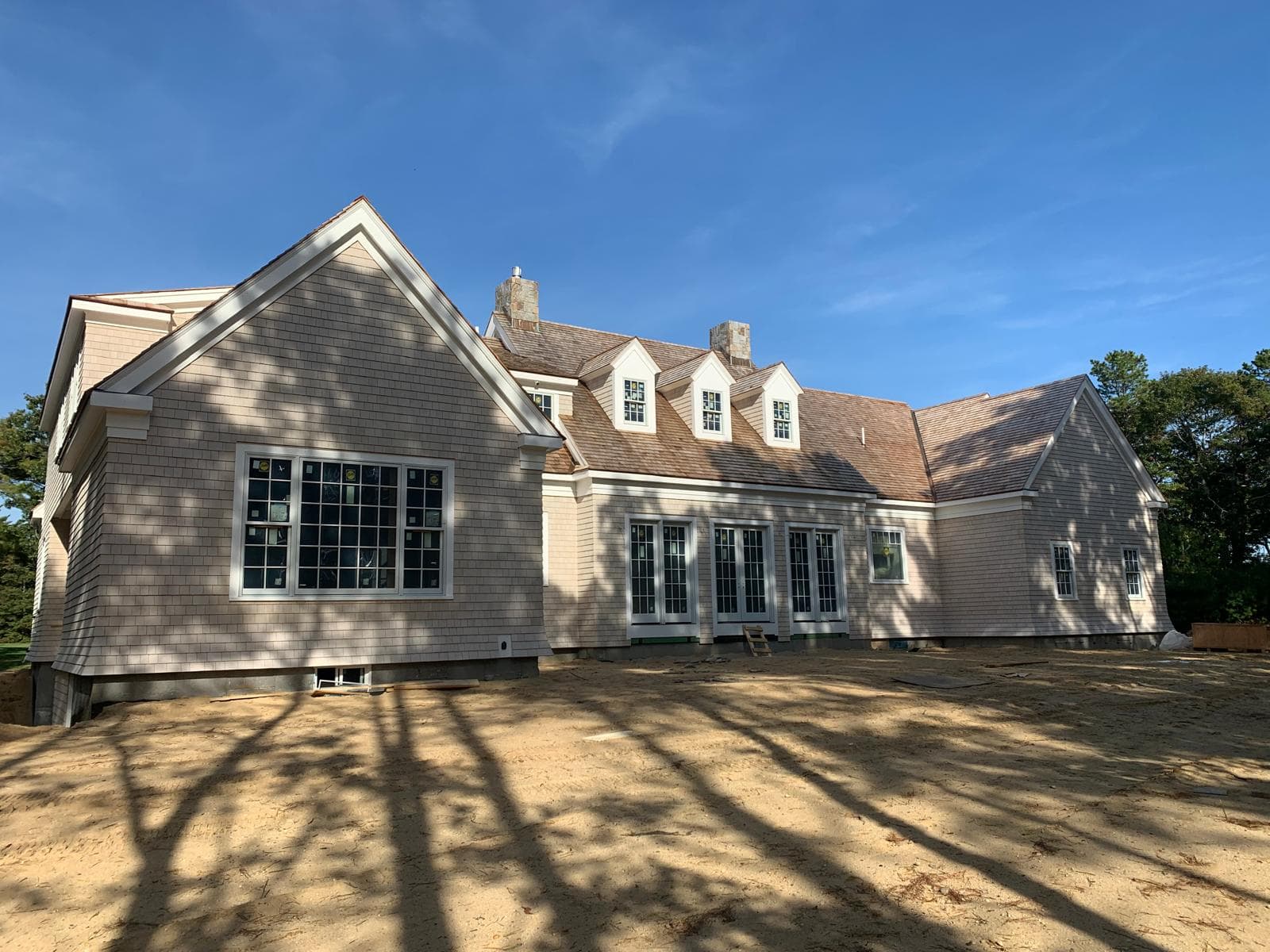 Shingle style estate across the back lawn in low sun
