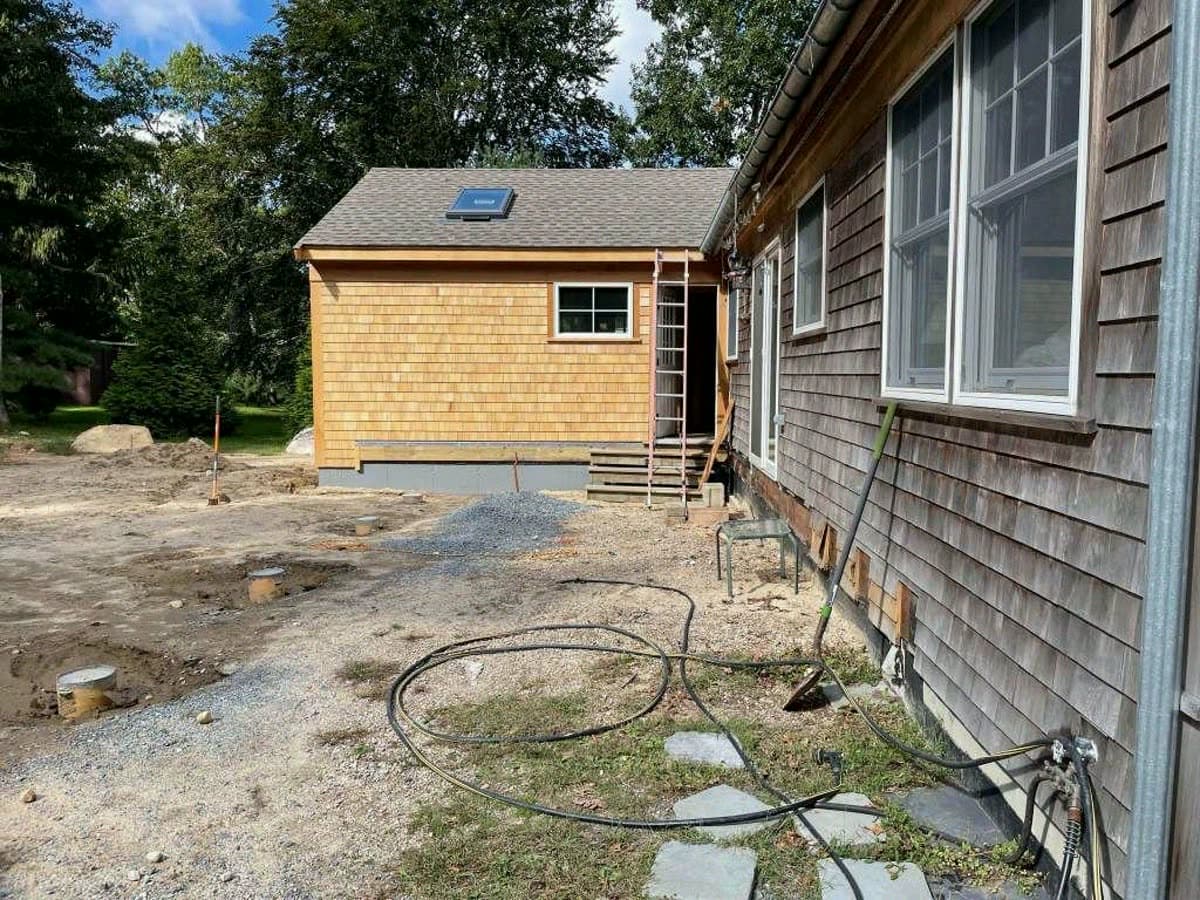 New cedar shingled addition beside the weathered original house